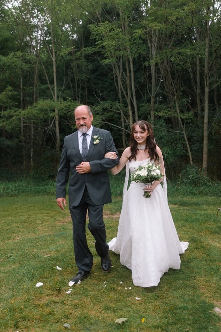 Shannon walking toward the outdoor wedding ceremony at Homestead Hollow County Park.