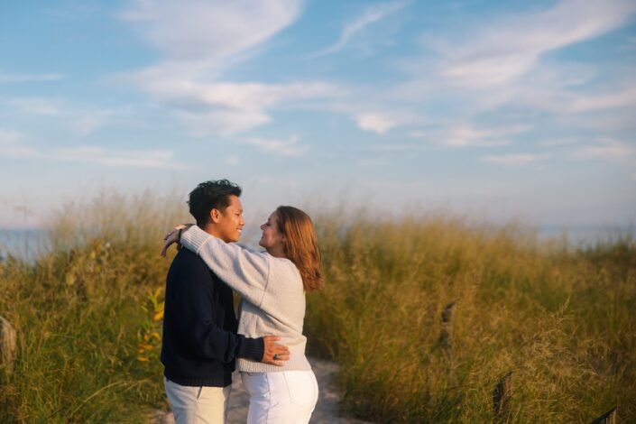 Nick and Katharine embracing in the golden hour light during their sunset engagement session.