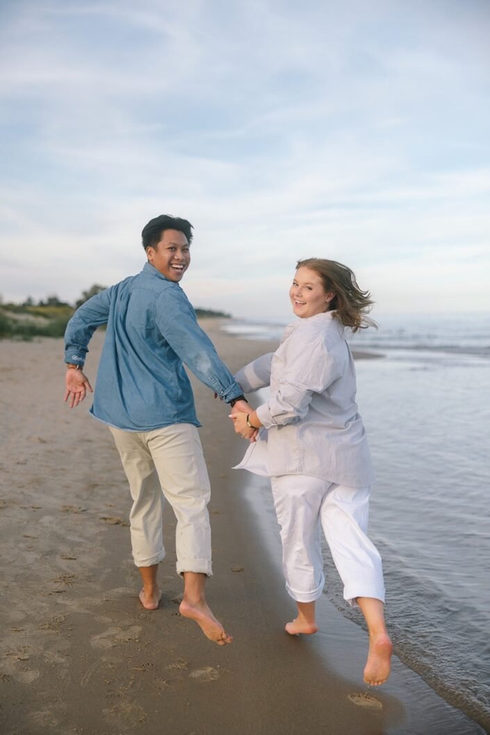 Nick and Katharine running together along the beach at Kohler-Andrae State Park.